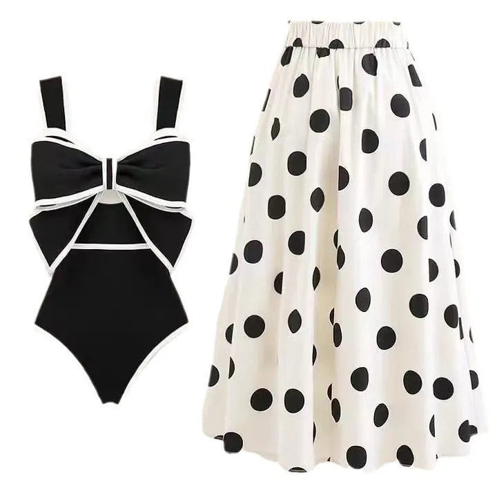 Women's black one-piece swimsuit with a white round skirt and a bow detail at the front.