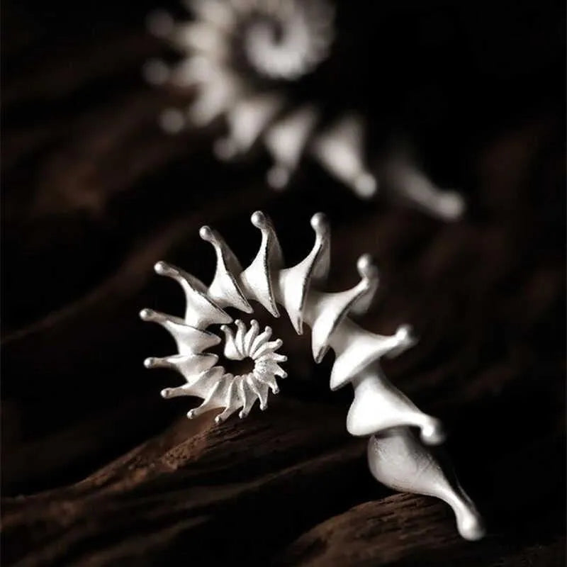 A pair of matte finish conch stud earrings with an exaggerated three-dimensional and irregular design.