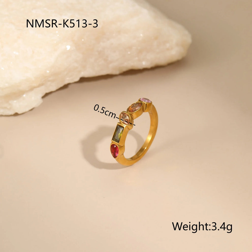 Geometric colour zircon gold plated jewellery set showing necklace, earrings and ring on black background