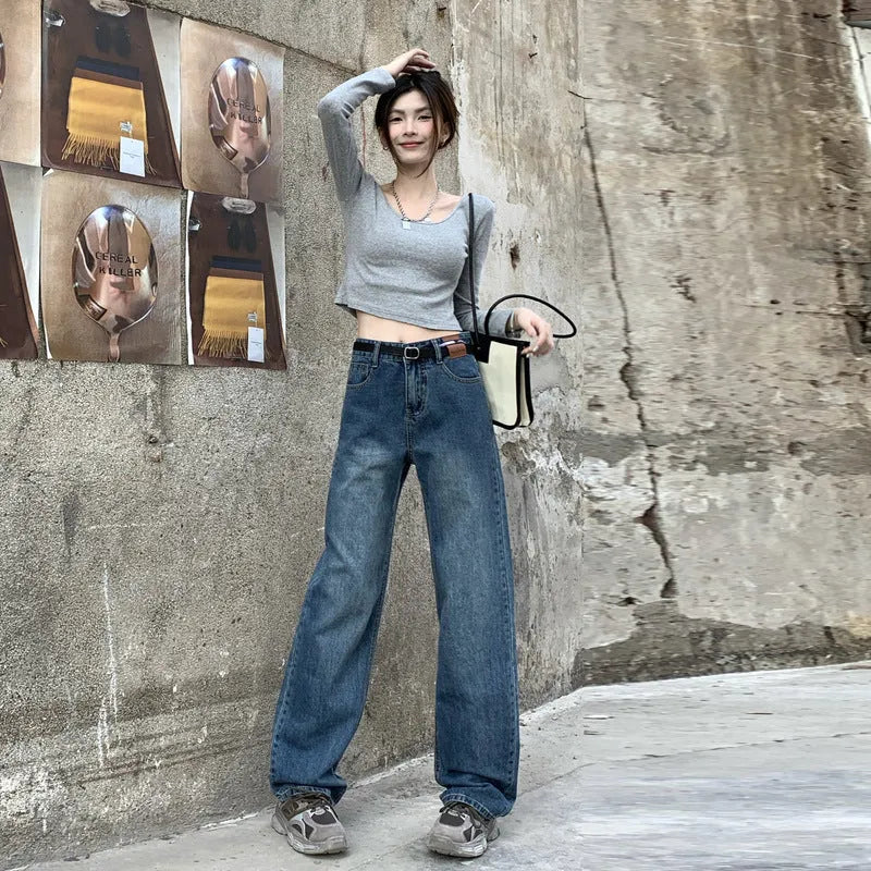 Women's retro blue high-waisted straight-leg jeans on a hanger, showing front detail.