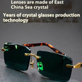 Dark green frameless crystal sunglasses with a glasses case and lens cloth.
