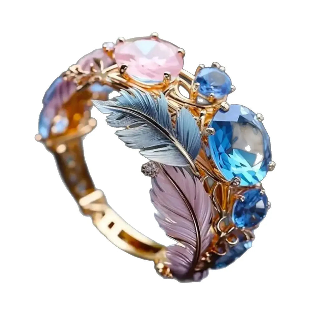 Gold coloured brass feather ring with embossed geometric design and colourful zircon inlays.