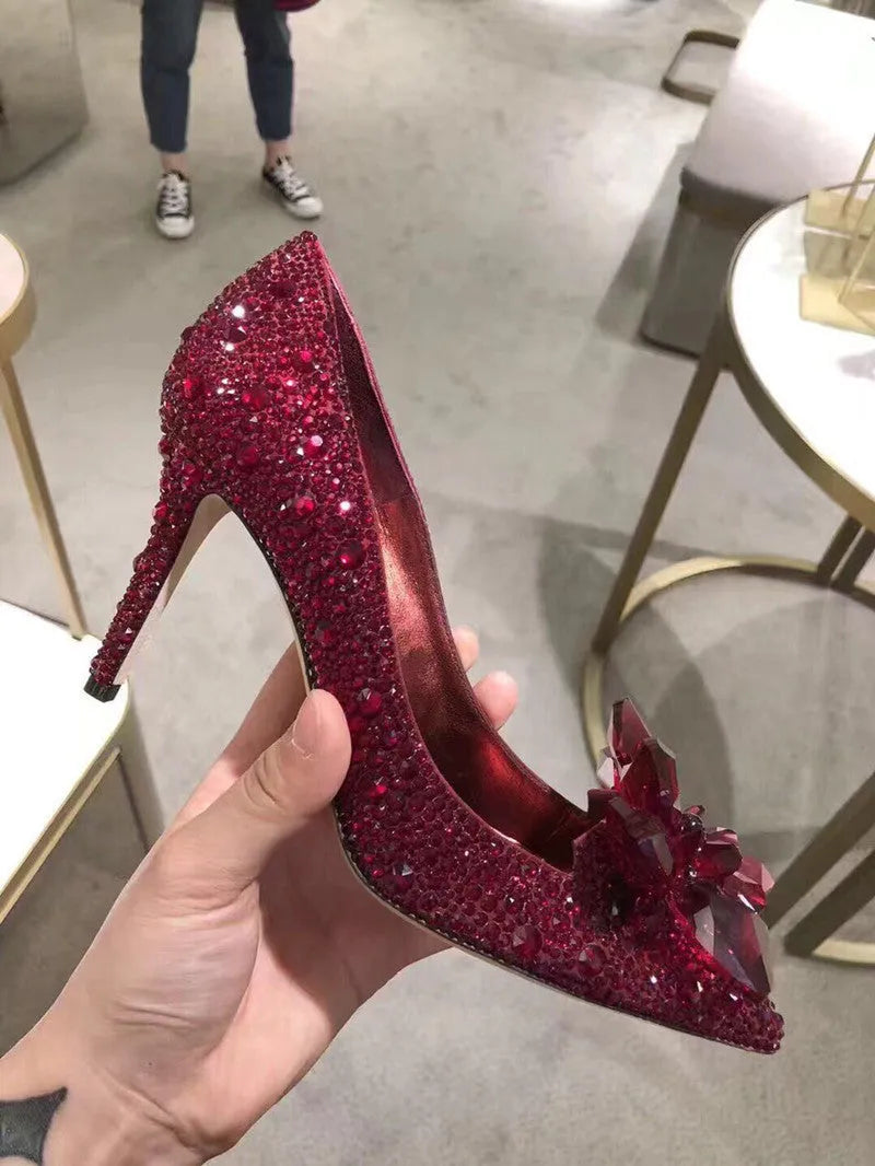 Gold women's high heel with pointed toe, rhinestones, and a stiletto heel on a white background.