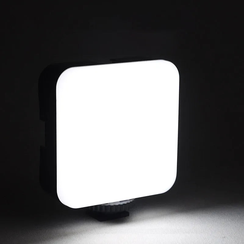 Compact square on-camera top flash unit with hot shoe mount and rotatable head.