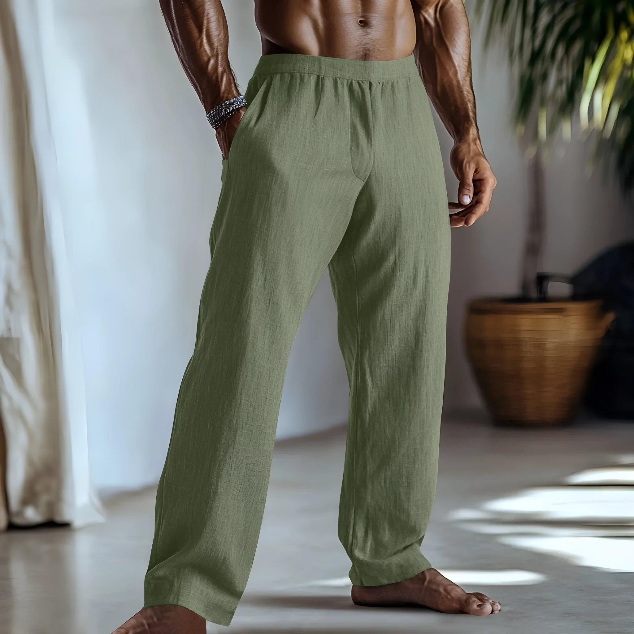 Straight leg cotton linen trousers in light green colour with visible front pockets on a plain background