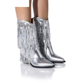 Women's black chunky heel tassel boots with a pointed toe and a high stiletto heel on a fashion runway.