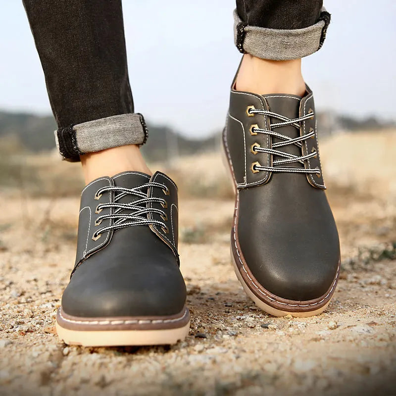 Men's black mid-top waterproof PU leather boots with a flat rubber sole.