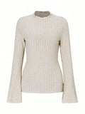 Man wearing a black long sleeve top with a subtle sunken stripe pattern and lantern sleeves.