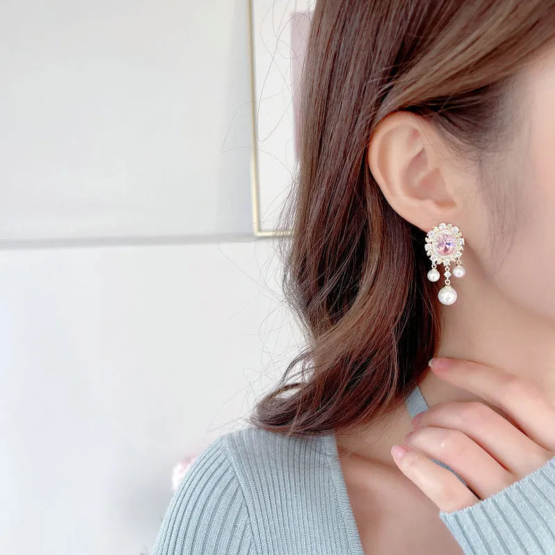 Oval geometric copper drop earrings with pearl elements, inlaid zircon treatment, and tassel detailing in light purple colour