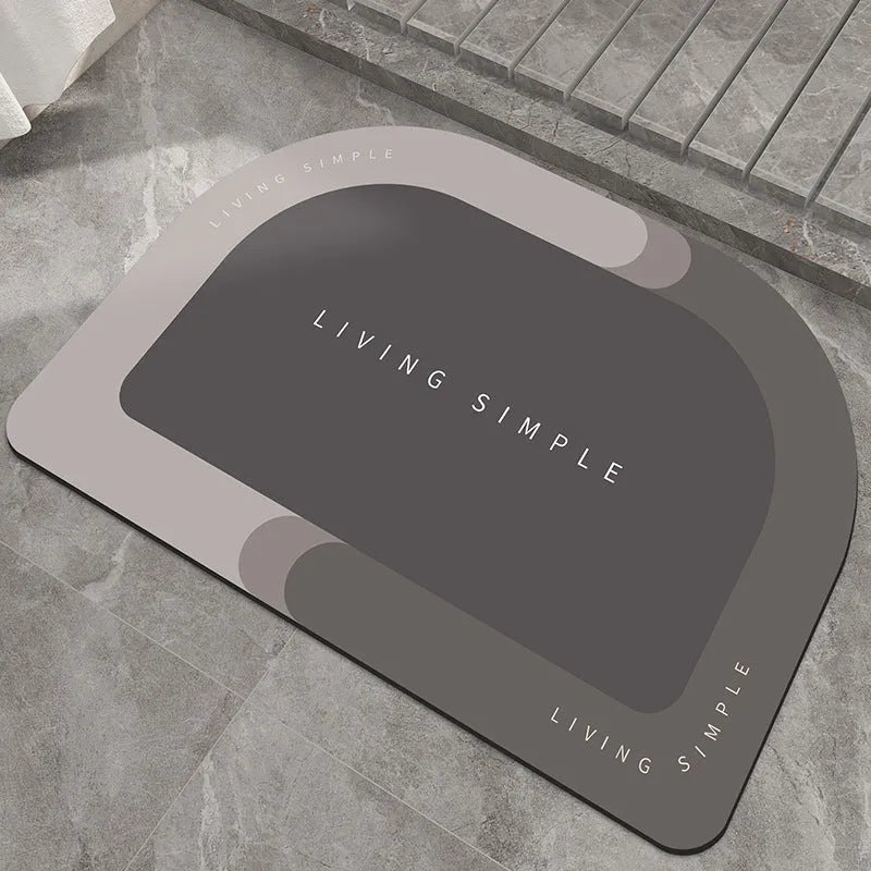 Grey oval super absorbent polyester bath mat with non-slip rubber bottom on tiled floor