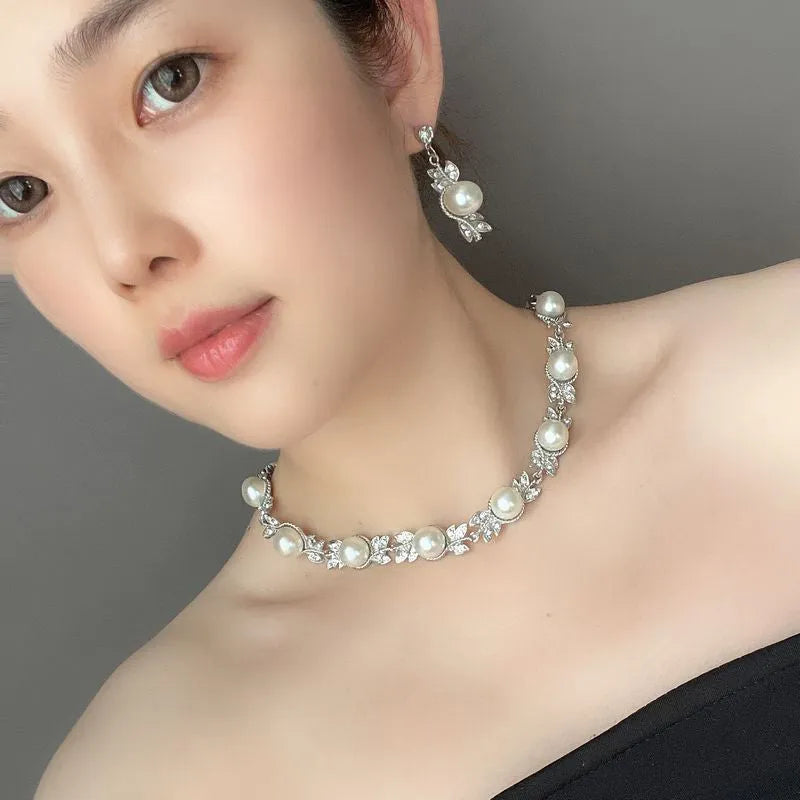 Three-piece jewellery set with rhinestone and pearl necklace, earrings, and bracelet in silver finish