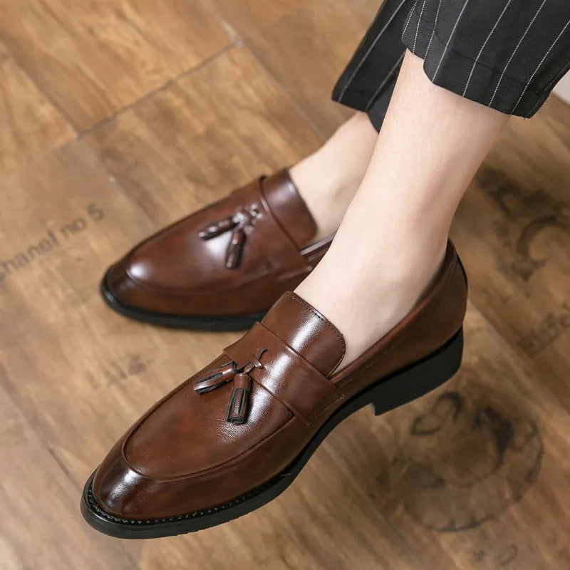 Men's black slip-on business casual shoe with a tassel detail on a low-top artificial PU upper.
