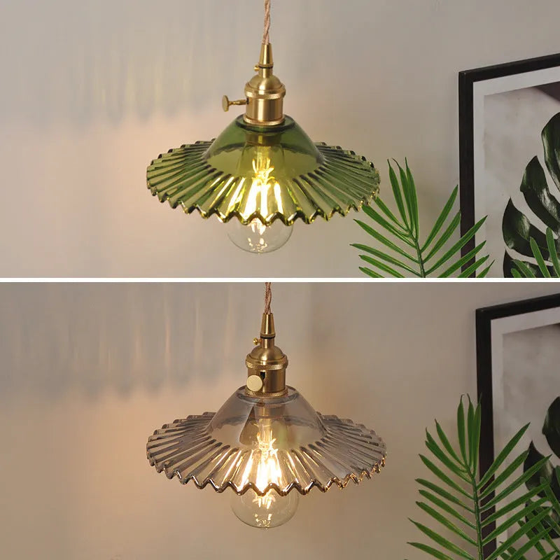 Retro brass copper lotus wall lamp with a glass shade in one of six colours, shown beside a bed.