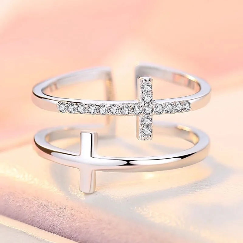 Adjustable double cross geometric ring made of copper with white gold finish and inlaid zircon stones.
