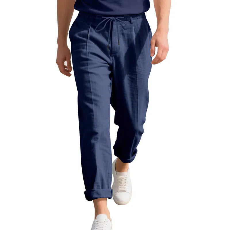 Men's light beige linen casual trousers with drawstring waist and straight-leg fit on a hanger.