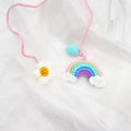Handmade crocheted avocado-shaped rainbow flower car pendant hanging, shown in multiple colour options.