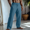 Straight leg cotton linen trousers in light green colour with visible front pockets on a plain background