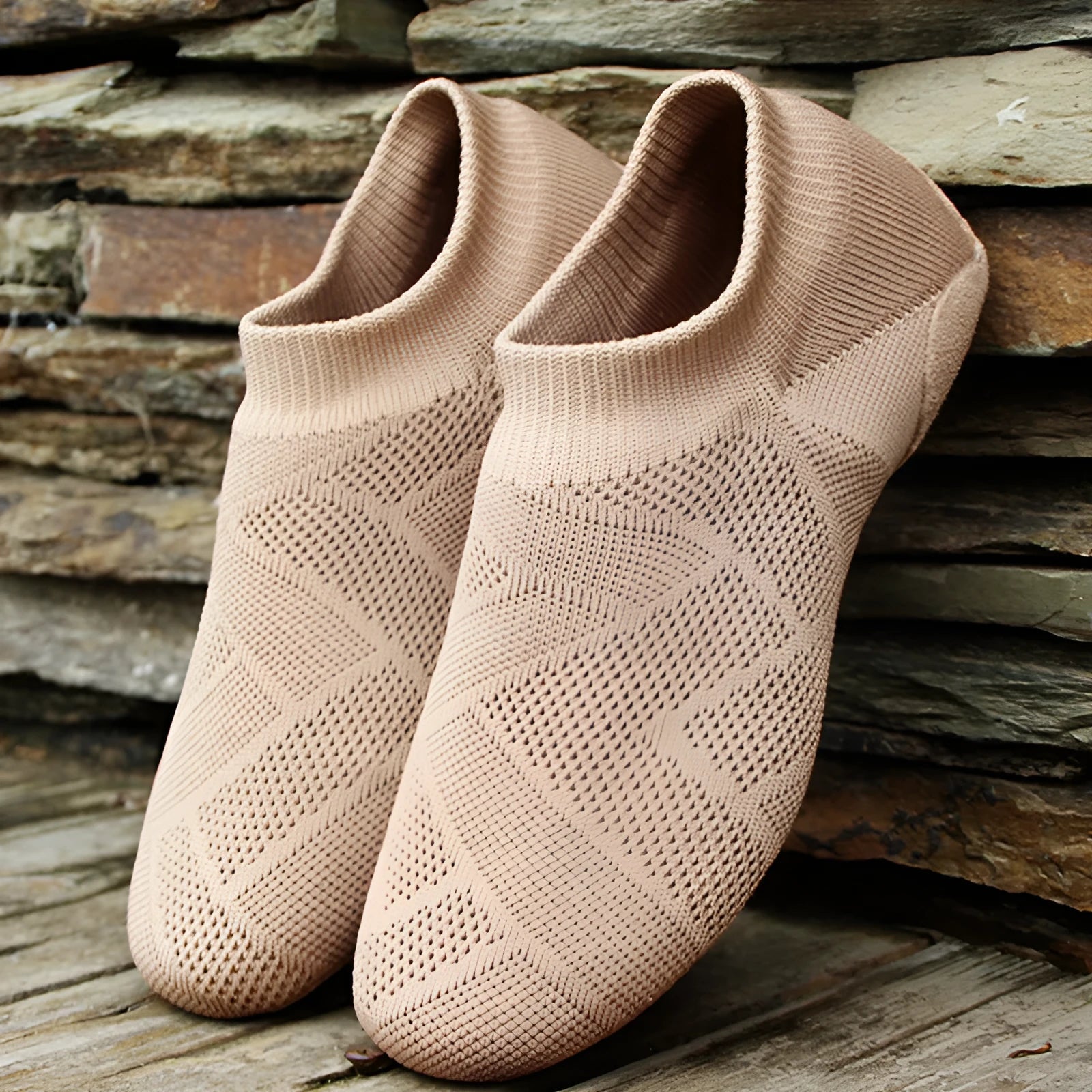 Camel colour dance yoga shoes with cotton mesh upper and leather sole on a plain background.