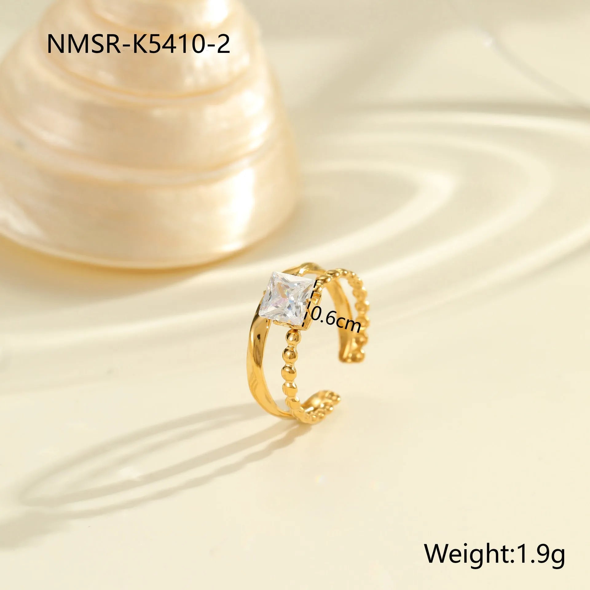 Gold-plated geometric stainless steel ring with inlaid zircon stones on a white background.