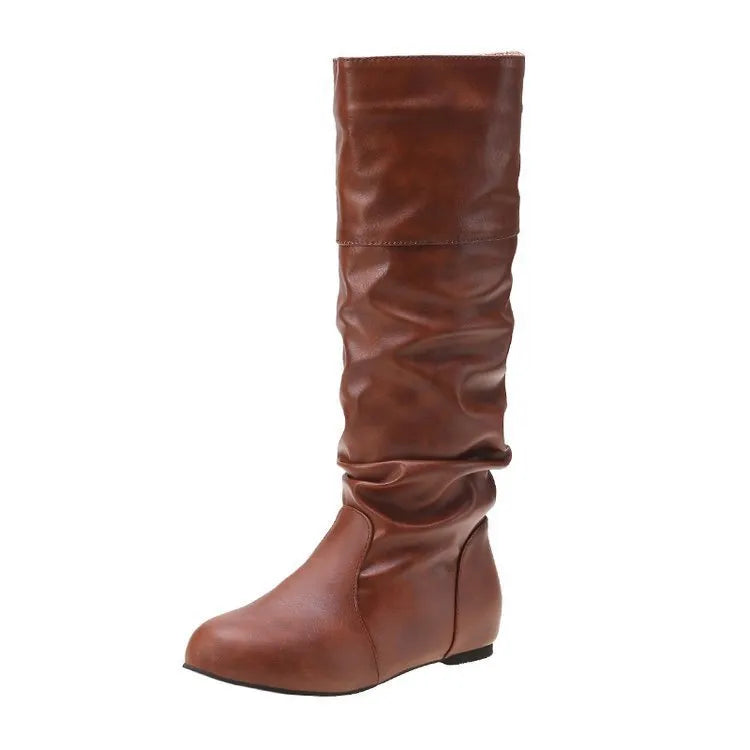 Women's black slip-on long boots with flat heel and round toe on a plain background.
