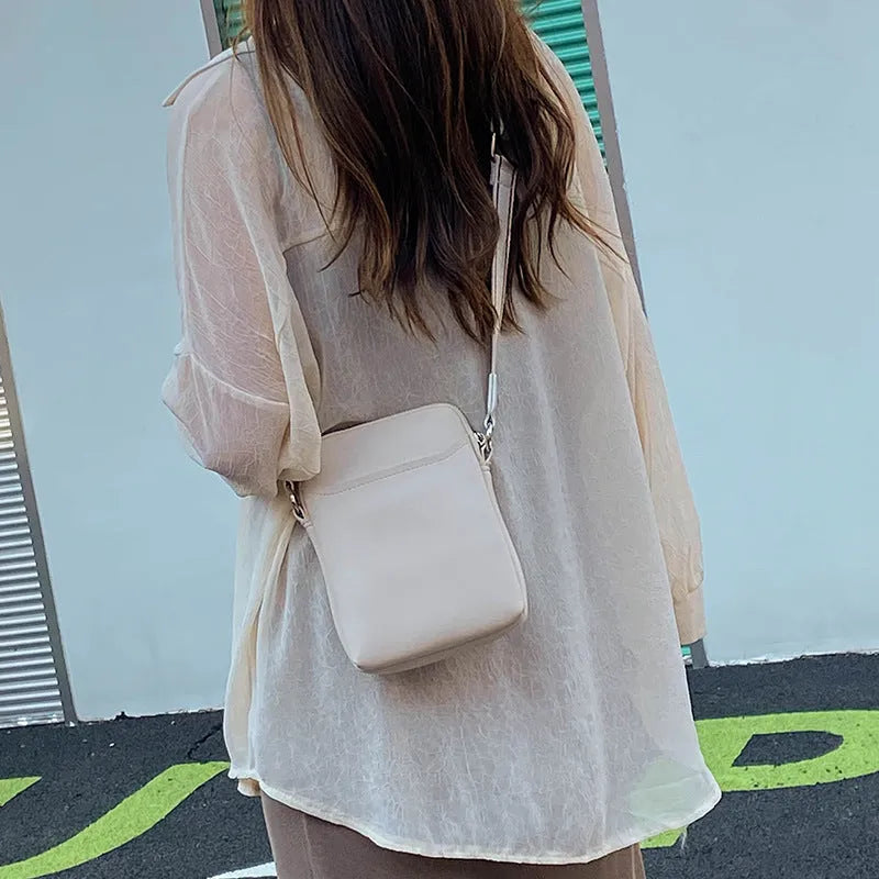 Solid colour small crossbody shoulder bag in PU leather measuring 14.5cm by 5.5cm by 19cm