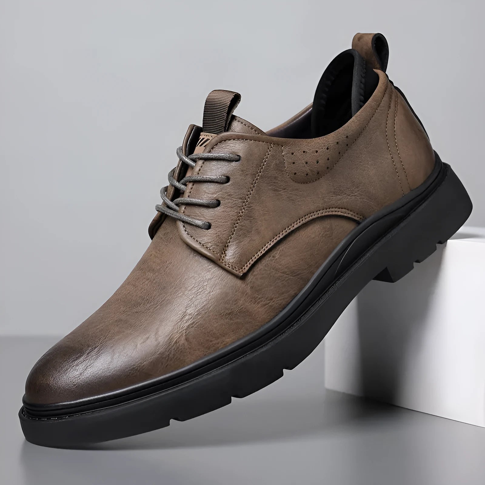 Men's black and brown leather casual sneakers with rubber sole and sewing line detail on the upper.