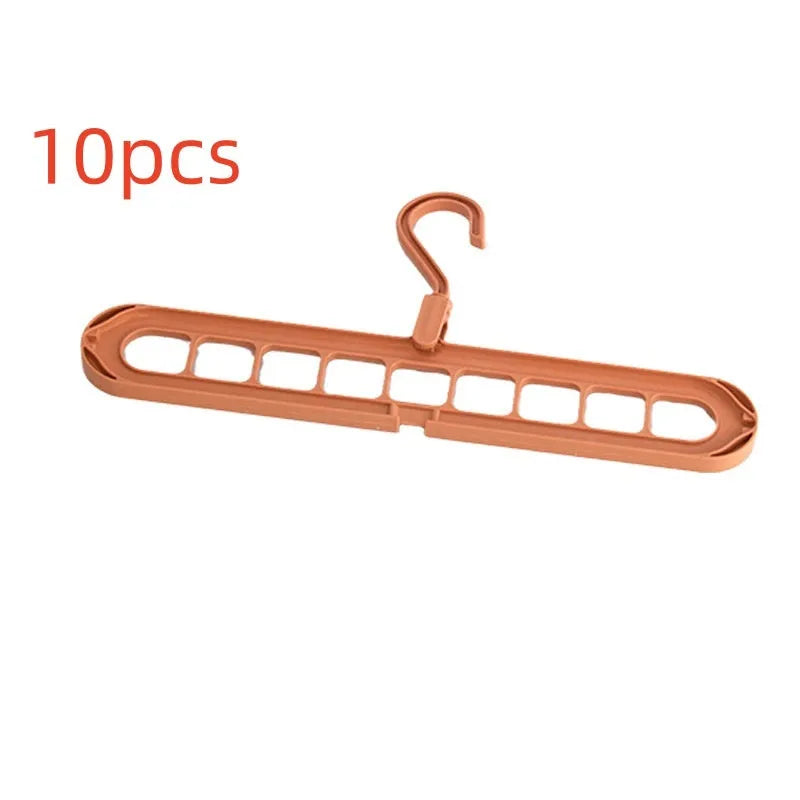 Green plastic nine-hole folding hanger for trousers shown in a dormitory wardrobe.