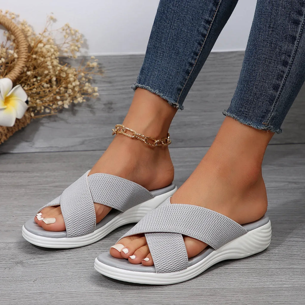 Women's black wedge slippers with peep-toe design and cross-strap PVC upper on thick rubber sole