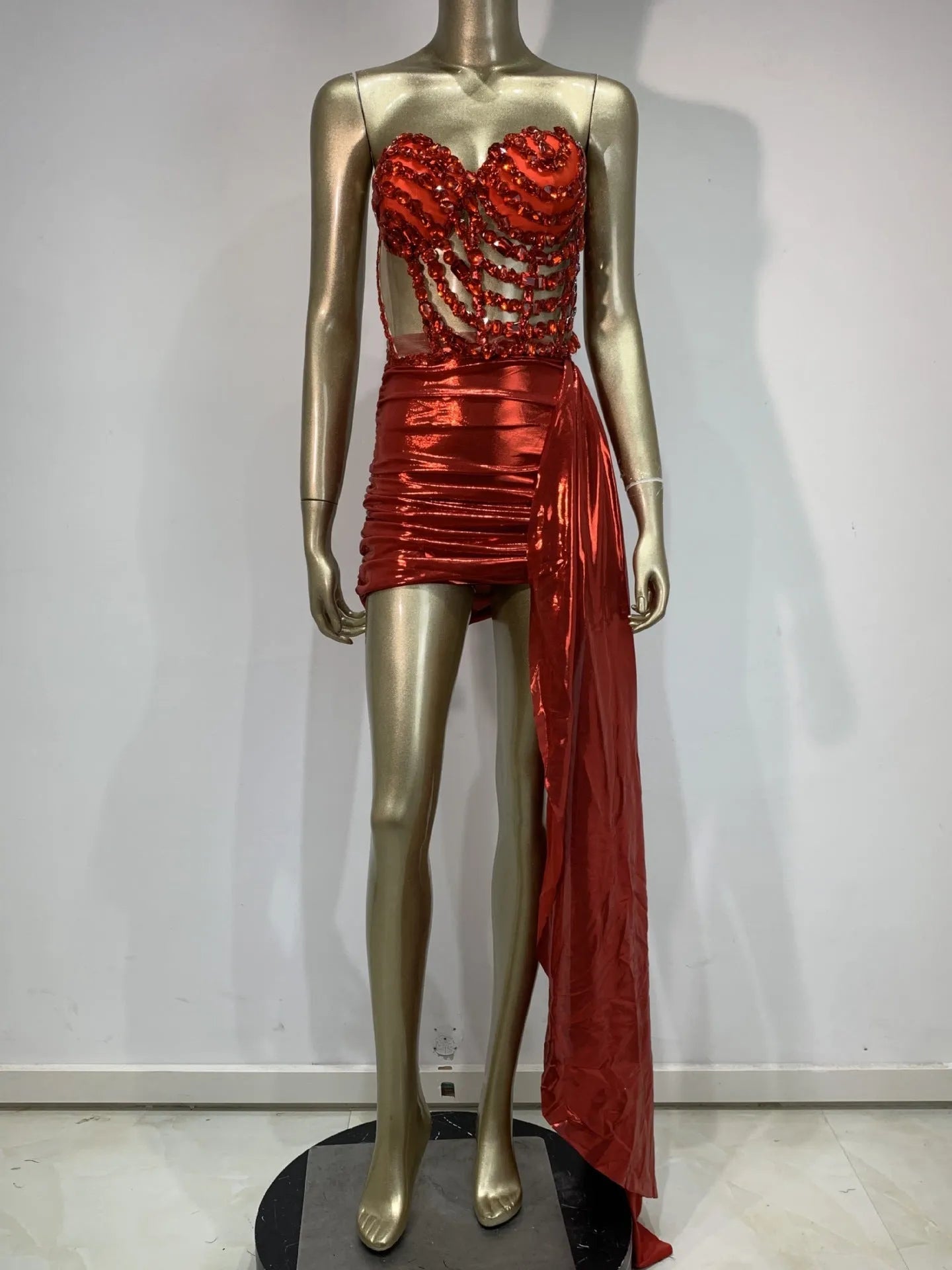 Red women's skirt suit with see-through mesh panels, made from stretch spandex fabric.