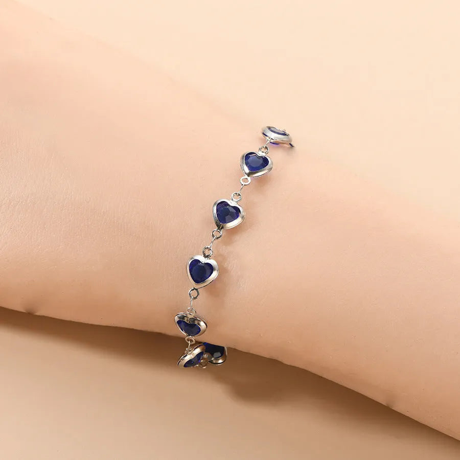 Devil's Eye geometric heart bracelet in stainless steel, shown in colourful, blue, green, and red finishes.