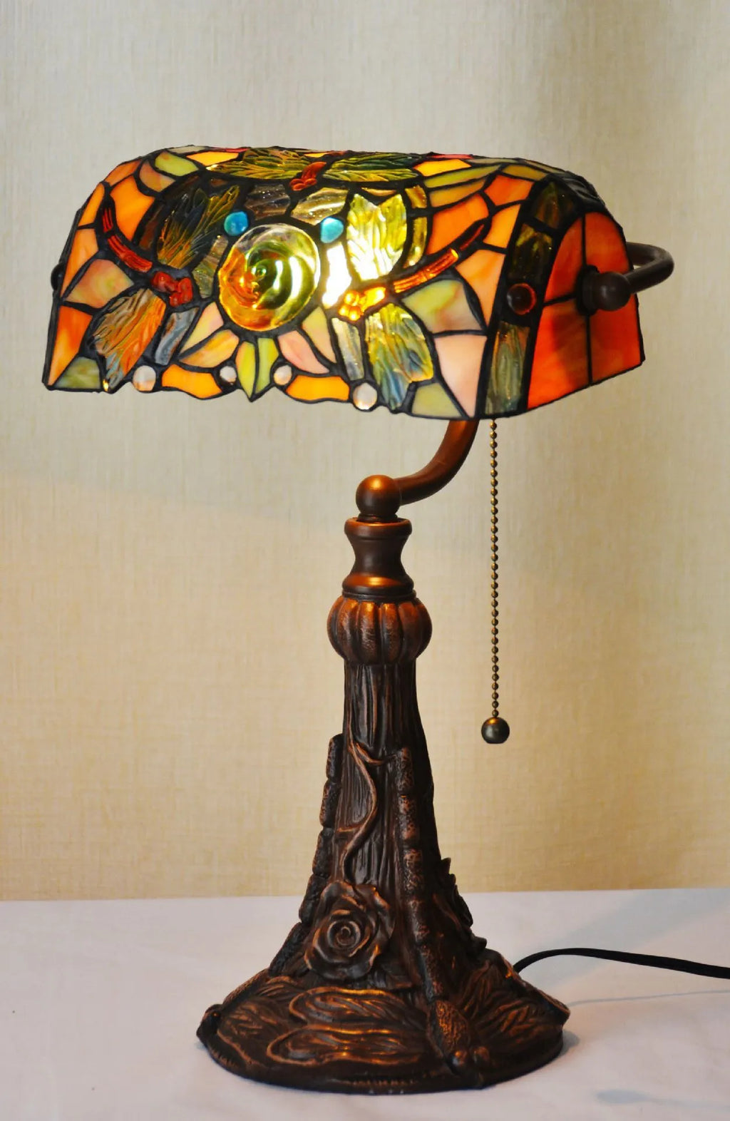 10-inch Tiffany style stained glass table lamp with resin base on a wooden desk.