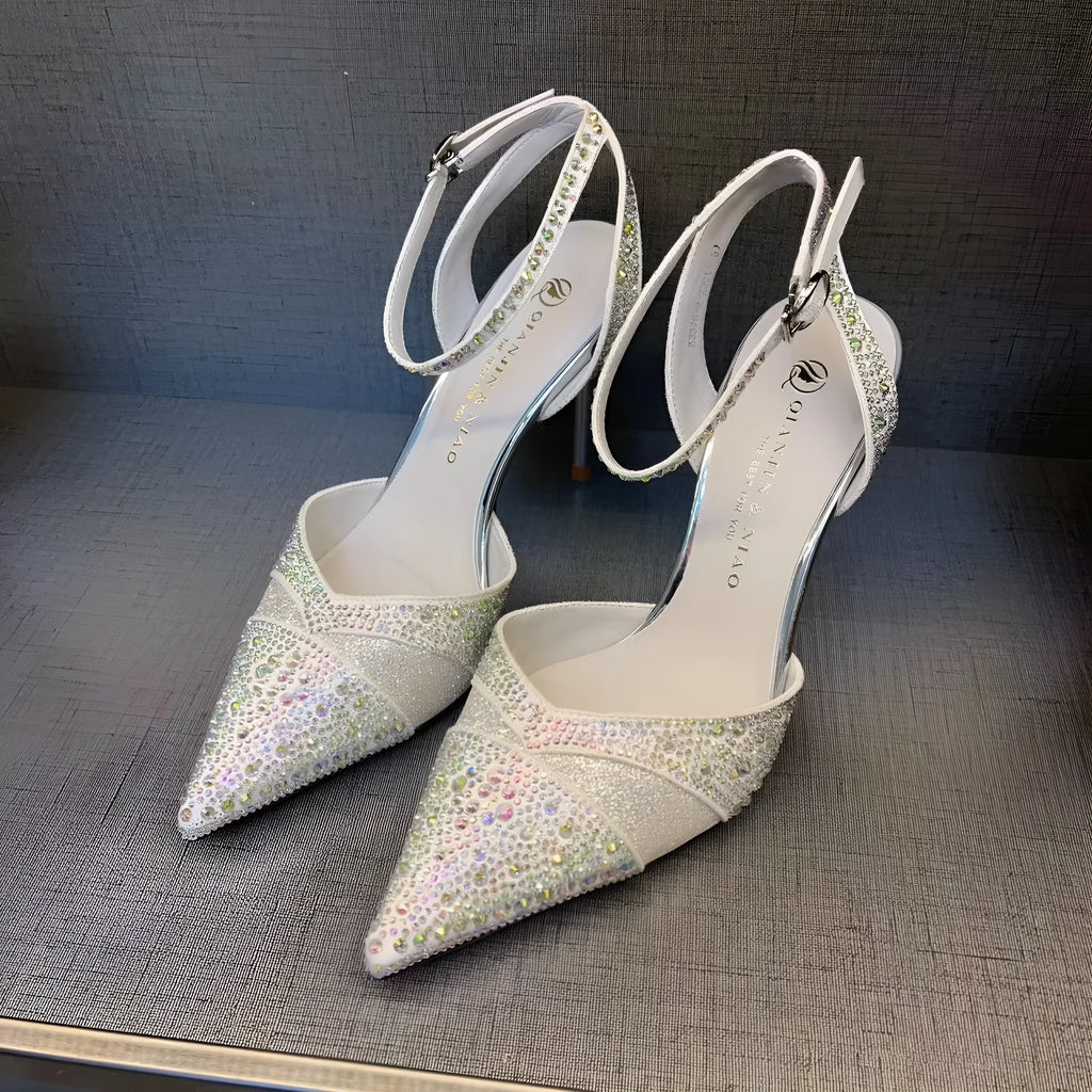 Women's silver high heels with hollow cut-out design and red stiletto heel sole.