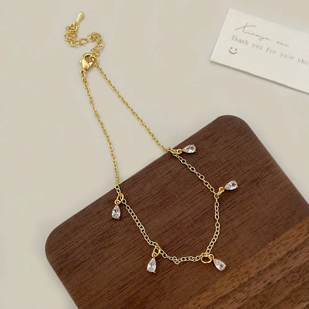 Women's zircon jewellery set showing geometric pendant necklace, matching earrings, and anklet with meteor shower design