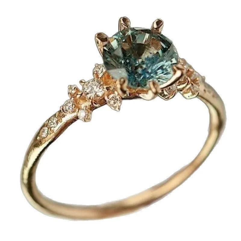 Gold plated geometric ring with claw setting holding zircon stones, showing chamfered square pattern detail