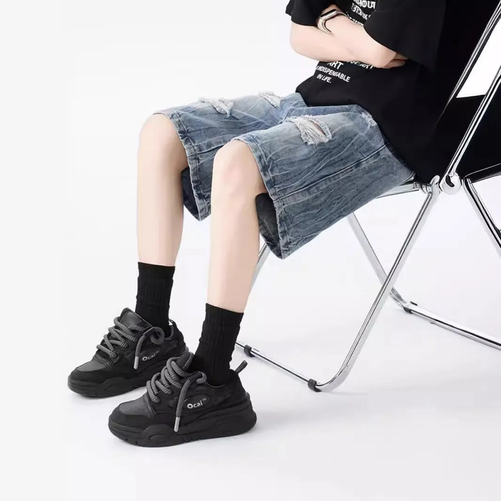 Men's loose-fit washed ripped denim shorts in black and blue colours with distressed detailing and retro styling