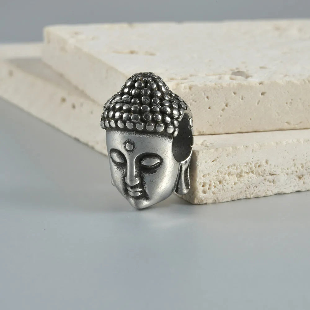 Geometric stainless steel earrings combining hollow skull and Buddha motifs with electroplated finish
