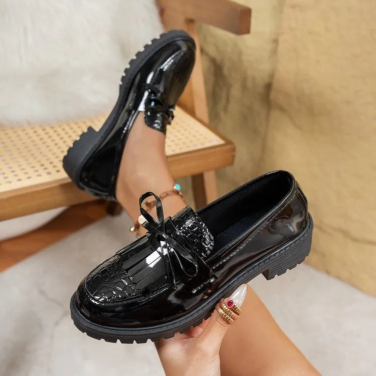 Women's brown and black loafers with bow detail on artificial PU upper, showing slip-on design
