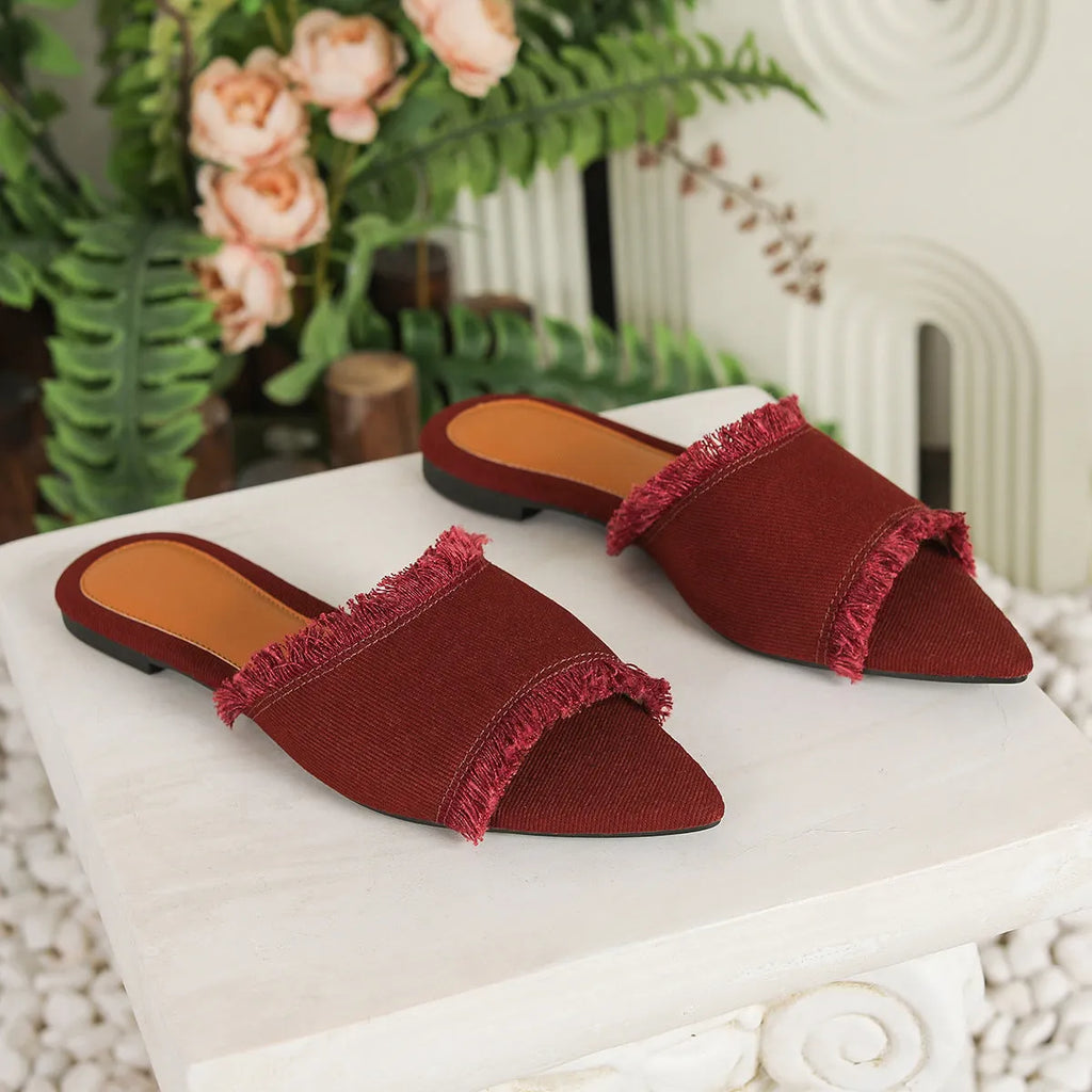 Women's casual denim flat slippers with leather lining and tassel detail.