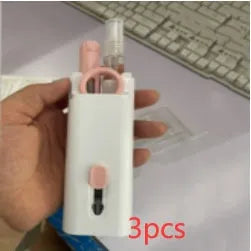 White cleaning set with pen, brush, keycap puller, and spray bottle on desk