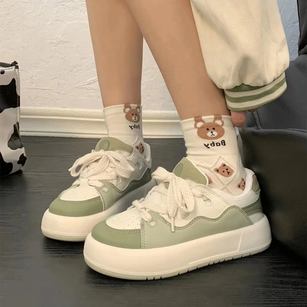 Green women's casual flat-heel sneakers with a mesh upper and round toe.