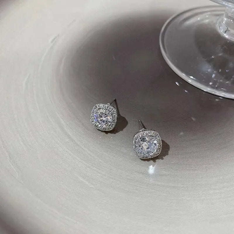 A pair of square-shaped diamond-treated alloy earrings on a white background, showing silver and gold colour options.