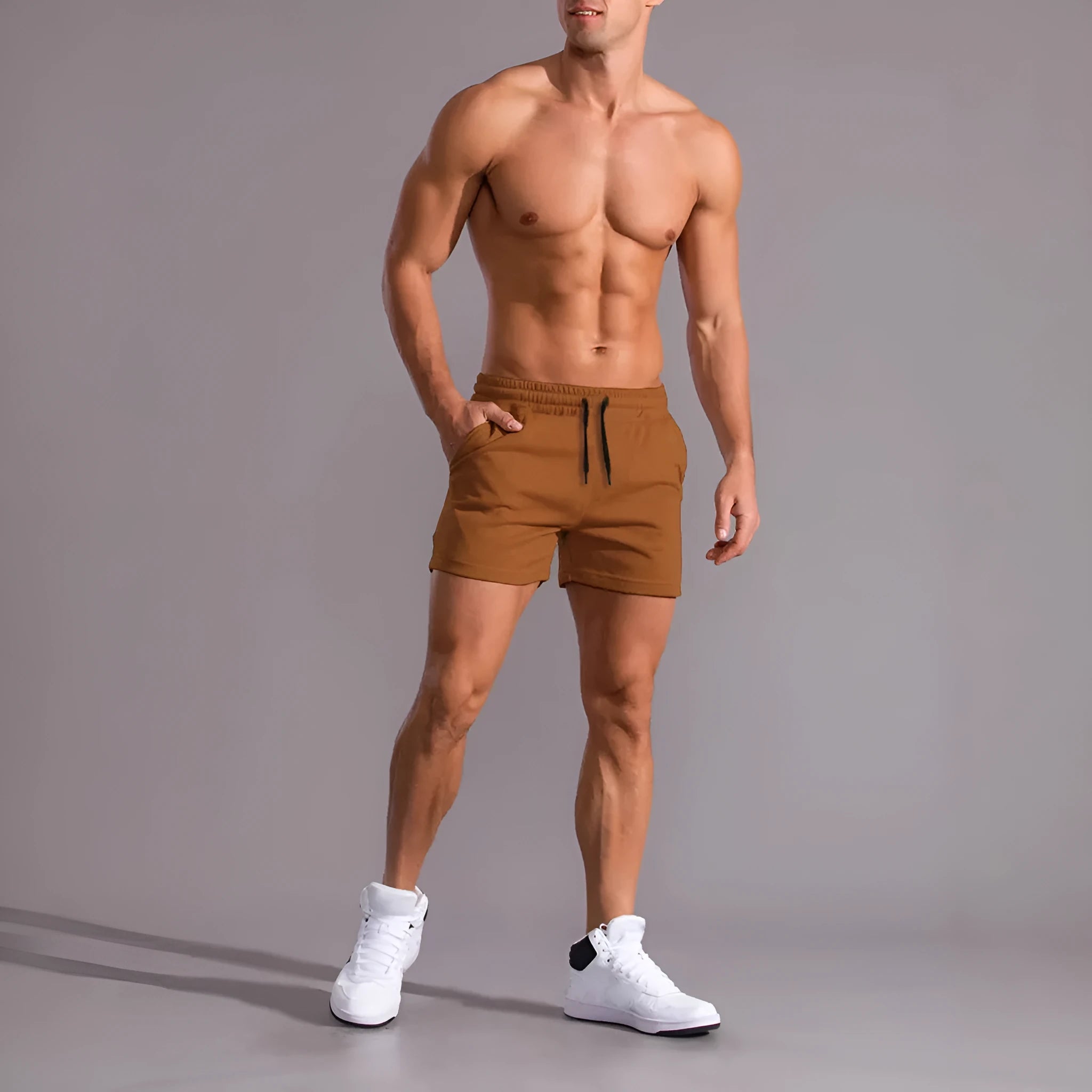 Three men's solid colour drawstring shorts laid flat showing loose fit and adjustable waistband.