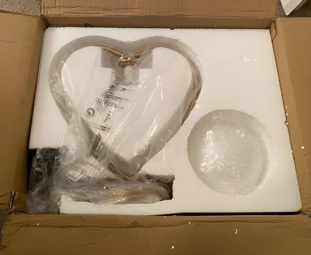 Pink heart shaped acrylic table lamp on a table next to a bed.