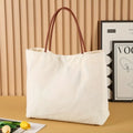 Heavy-duty natural canvas tote bag with long straps and reinforced bottom in beige white colour.
