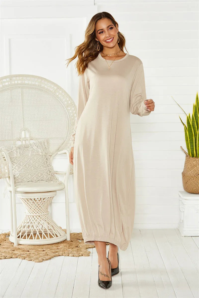 A grey loose-fitting long lantern dress with long sleeves and a crew neckline, laid flat.