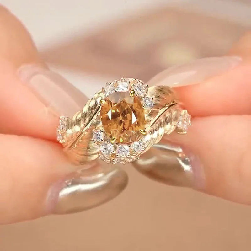 Gold-coloured embossed feather ring with geometric shape and zircon inlay, shown in women's fashion jewellery style
