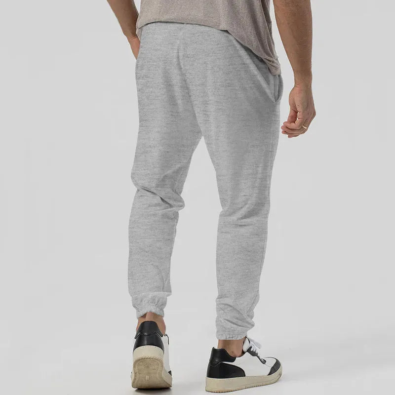 Men's gray elastic track sweatpants with straight-leg tapered design and mid waist