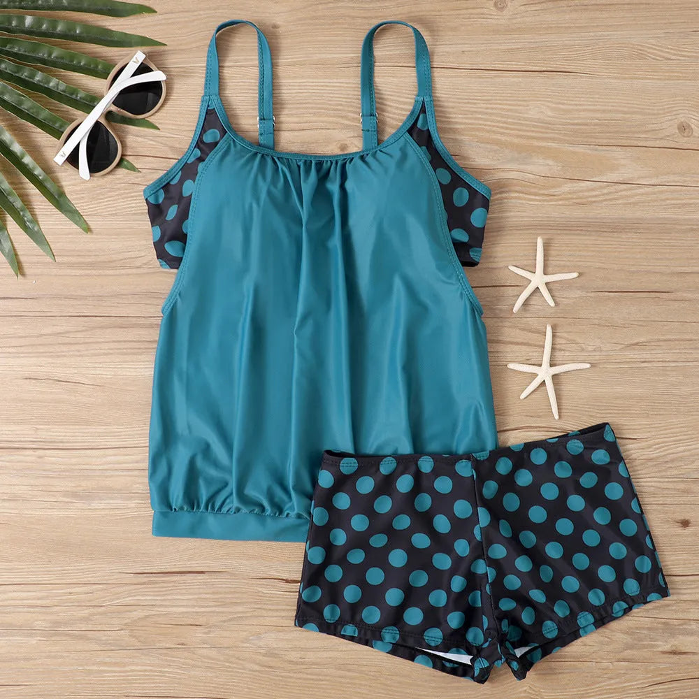 Women's black polka dot high-waist swimsuit with conservative briefs style on a mannequin.