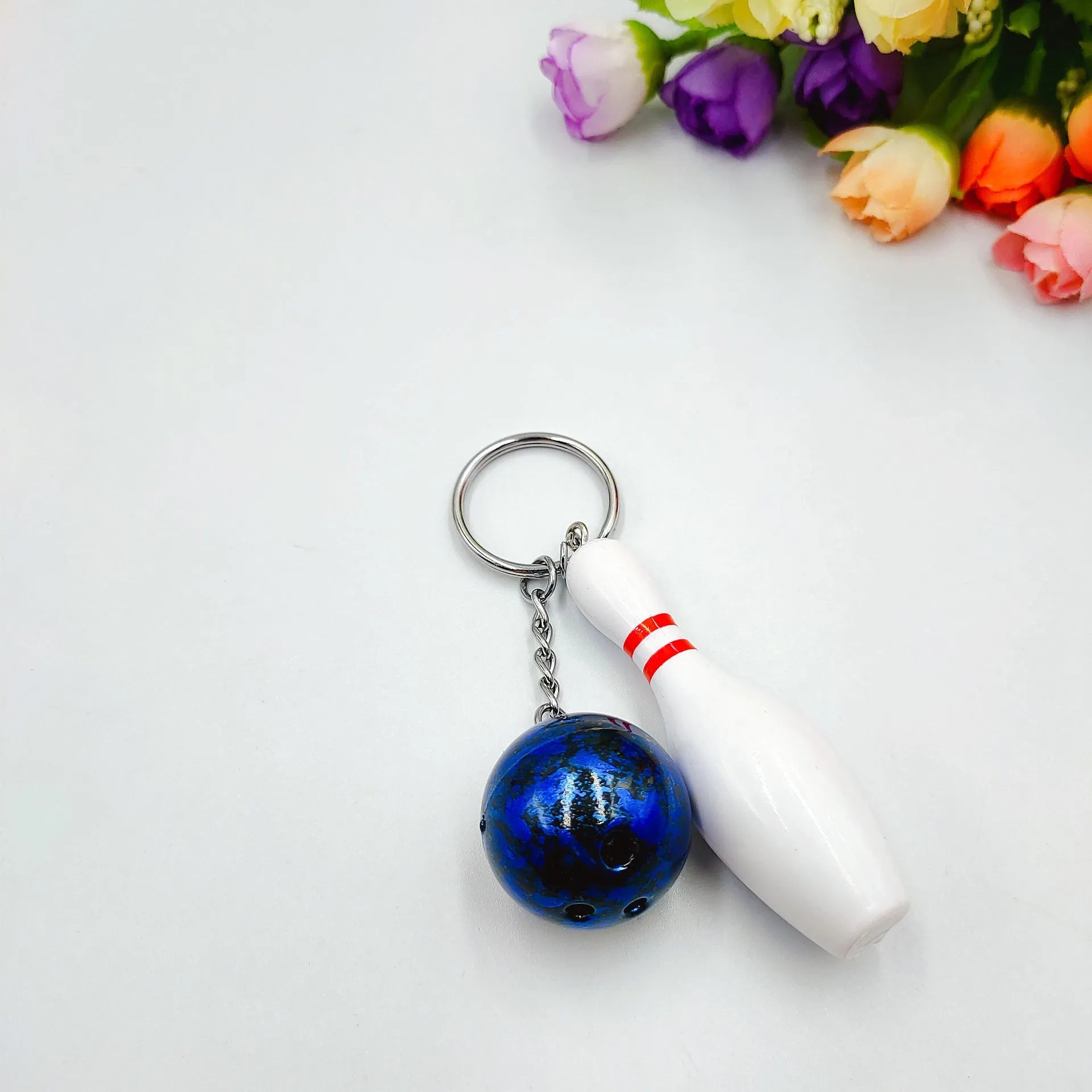 Mini bowling pin simulation keychain pendant in blue, made from PVC and metal on a key ring.