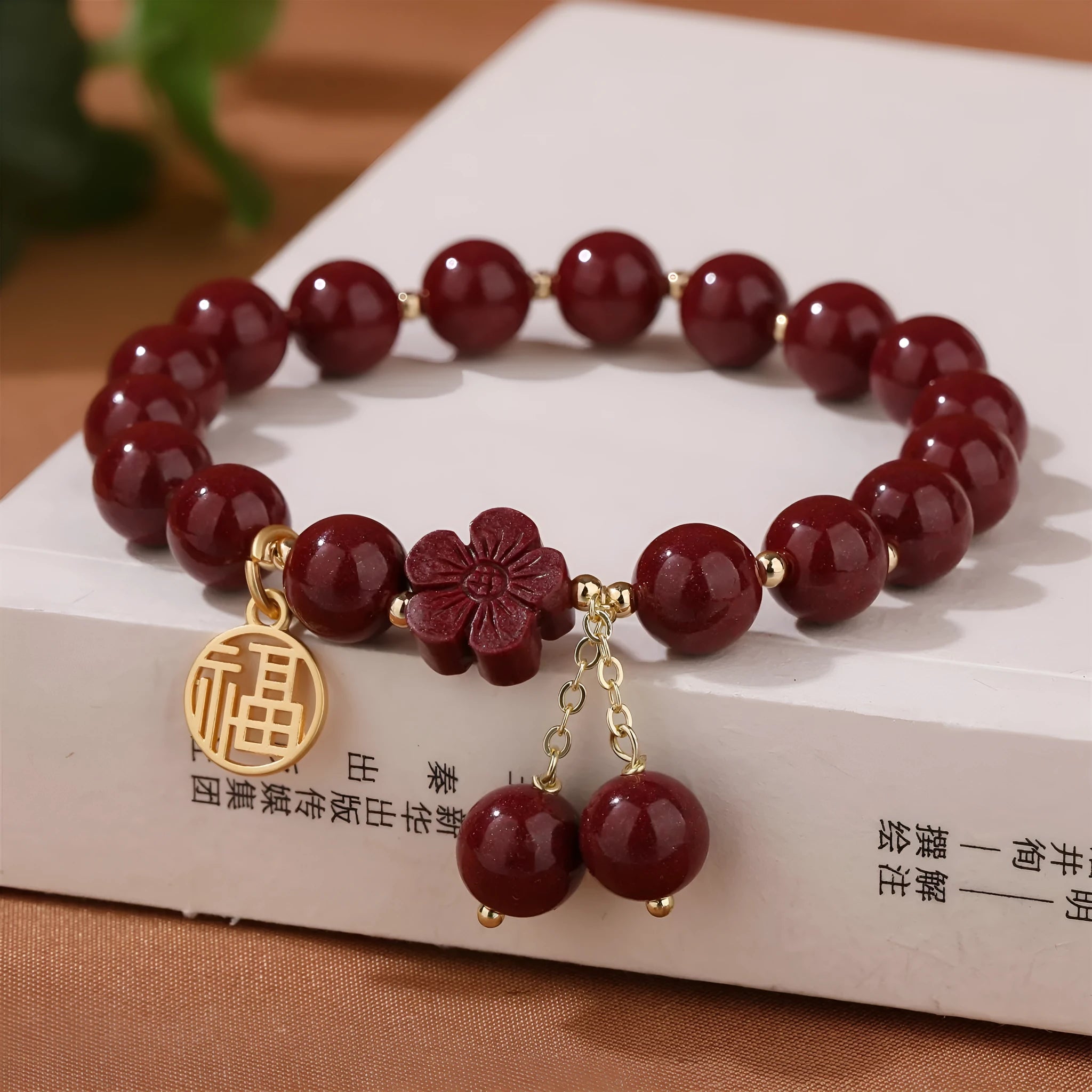 Women's cinnabar bracelet with fu character charm in purple gold sand colour and peach blossom detailing